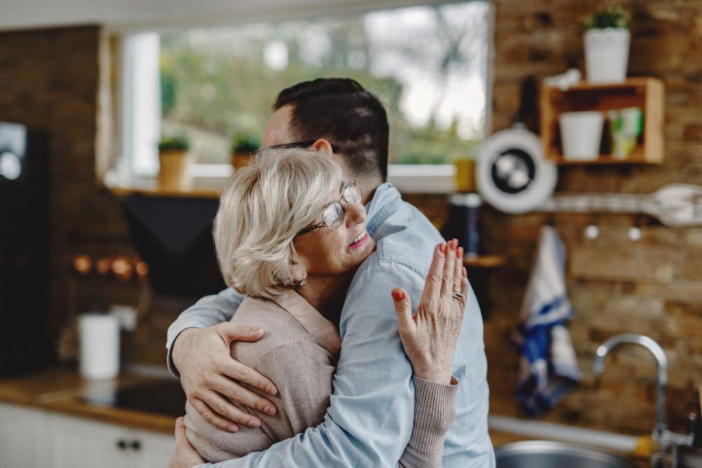 A mother hugging her adult child.