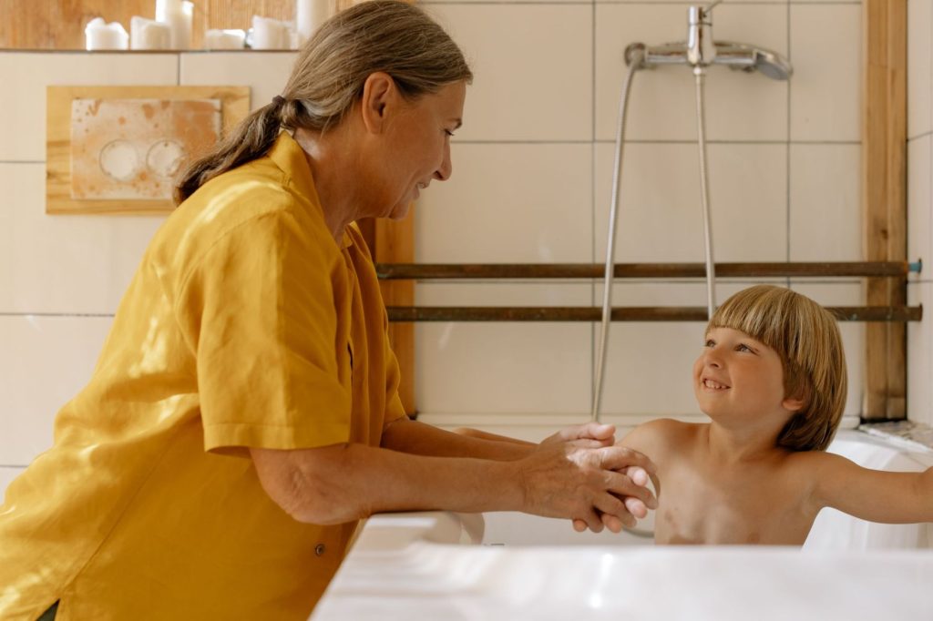 A grandmother bathing her grandchild.