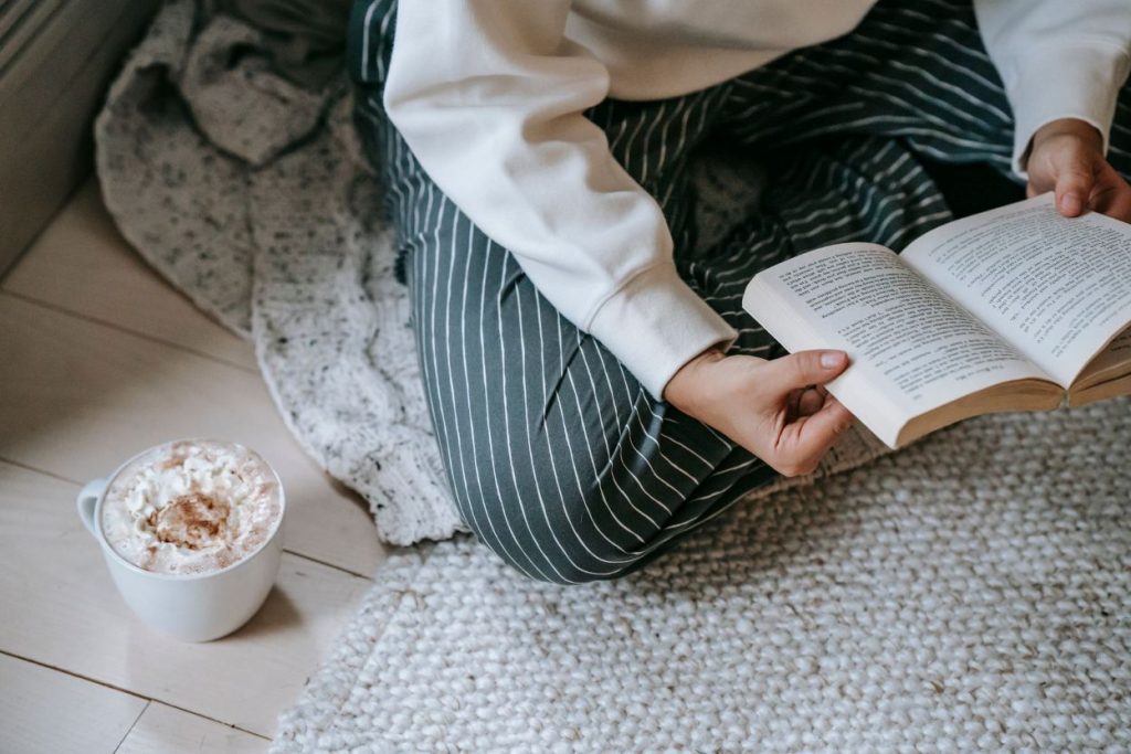 A woman sitting down and reading.